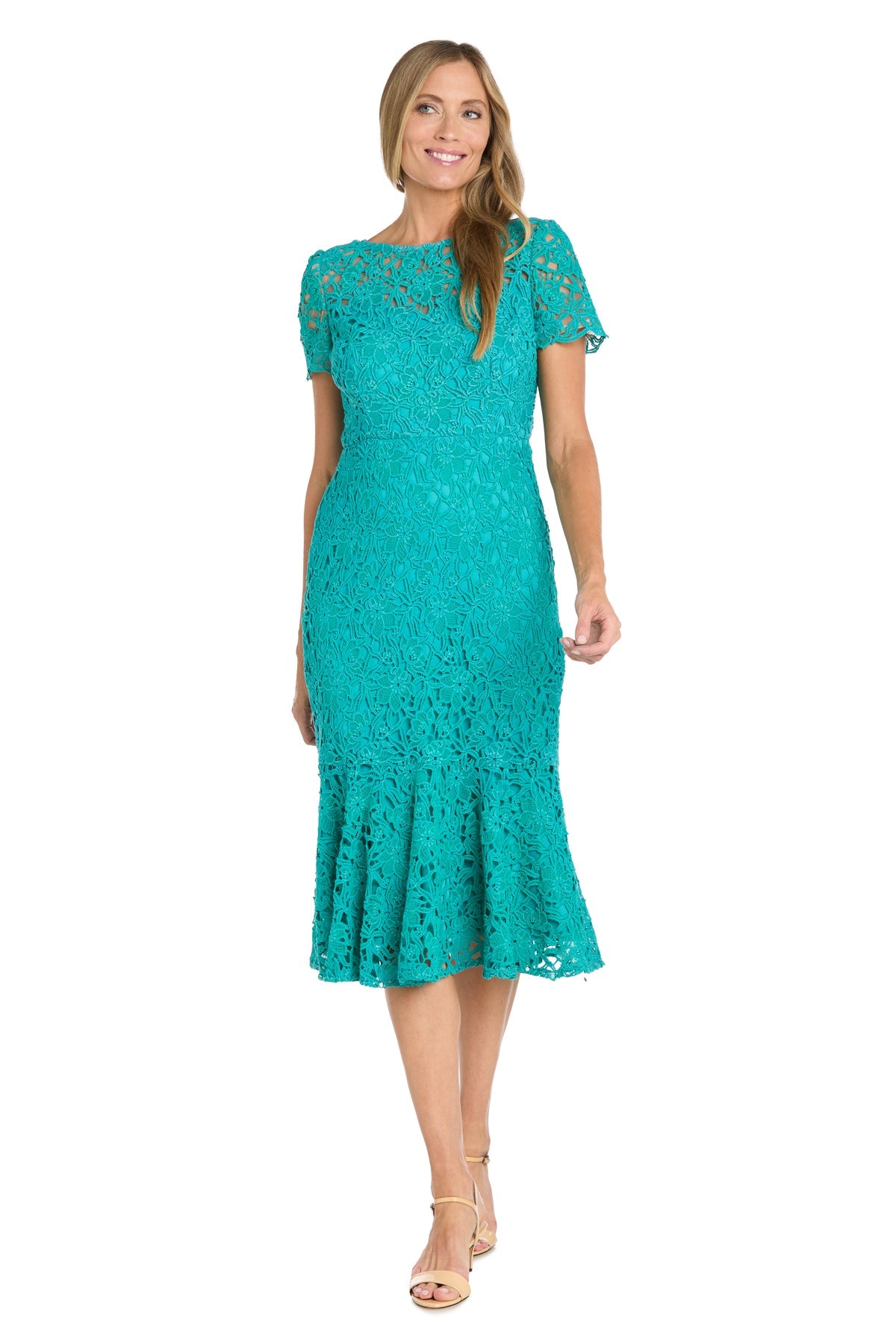 A woman wears the R&M Richards 3498 midi lace wedding guest dress in teal with short sleeves and a ruffled hem, paired with strappy beige heels.
